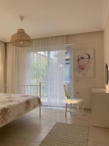 a bedroom with a bed and a chair and a window at Kaya Suite in Fethiye
