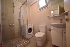 a bathroom with a toilet a sink and a washing machine at Kaya Suite in Fethiye