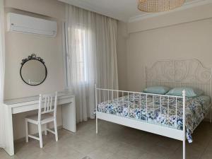 a bedroom with a bed and a desk and a mirror at Kaya Suite in Fethiye