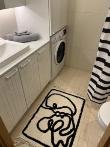 a bathroom with a washing machine and a rug at Suburb stay by Overnight.ee in Petrikyula