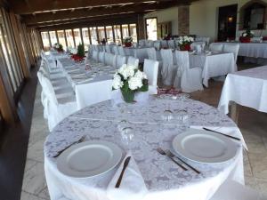 a group of tables with white plates and flowers on them at Hotel Corsaro Nero in Portu Maga