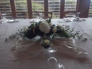 a table with a bouquet of flowers and wine glasses at Hotel Corsaro Nero in Portu Maga