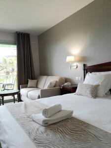 a hotel room with two beds and a couch at Logis Hôtels- Hôtel et Restaurant Domaine de Fompeyre in Bazas