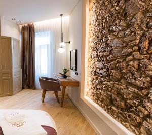 a room with a stone wall and a desk at Paleo Suites in Athens