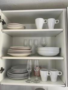a cabinet filled with plates and cups and dishes at Casa Ucraniana Wi-Fi fibra in Costa Calma