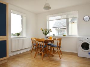 a kitchen and dining room with a table and chairs at Brook House in Trevilley
