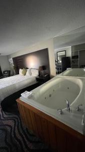 a hotel room with a bath tub and a bed at Country Town N' Suites in Gatlinburg