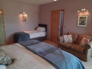 uma sala de estar com duas camas e um sofá em Oak Tree Lane Country B and B em Bridgetown