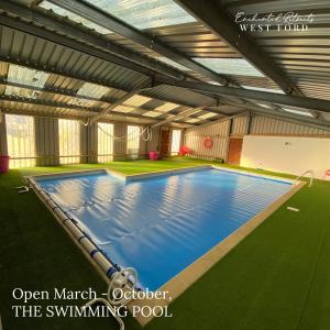 an indoor swimming pool with an open market octoberober the swimming pool at Enchanted Retreats at West Ford Devon in South Molton