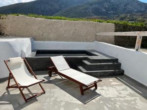 2 sillas sentadas en un patio con escaleras en Episkopi Estate Cycladic Villas, en Éxo Goniá