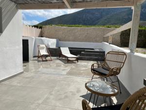 eine Terrasse mit 2 Stühlen, einem Tisch und Stühlen in der Unterkunft Episkopi Estate Cycladic Villas in Éxo Goniá