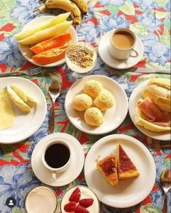 a table with plates of food and a cup of coffee at Pousada Primavera in São Luiz do Paraitinga