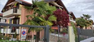 una valla frente a un edificio con una palmera en New Home en Ferno