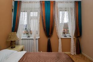 a bedroom with a bed and two windows at Elegant Visoko in Visoko