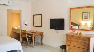 een kamer met een bed, een tafel en een spiegel bij ARMIDA EXPRESS in Guaymas