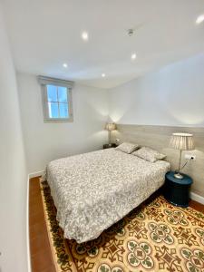 ein weißes Schlafzimmer mit einem Bett und einem Fenster in der Unterkunft Suite Apartment Anselm Barcelona in Cornellà de Llobregat