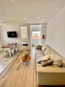 uma sala de estar com um sofá e uma mesa em Suite Apartment Anselm Barcelona em Cornellà de Llobregat