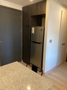 uma cozinha com um frigorífico de aço inoxidável num quarto em Piso 13 Concepcion em Concepción