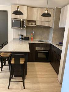 cocina con mesa, sillas y microondas en Piso 13 Concepcion, en Concepción