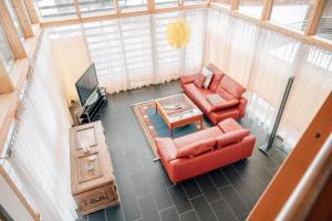 una vista aérea de una sala de estar con un sofá rojo en Reiterhof Berggut Gaicht, en Nesselwängle