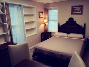 ゲティスバーグにあるSleepy Hollow Manorのベッドルーム1室(ベッド1台、テーブル、椅子付)