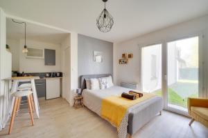 a small bedroom with a bed and a kitchen at Le studio d'Angèle in Bruz