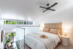 1 dormitorio con 1 cama y ventilador de techo en Caribbean Noosa, en Noosa Heads