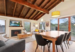 Un comedor con mesa y sillas y chimenea. en Kenyons Koppie, en Dinner Plain