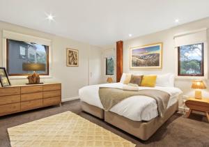 Un dormitorio con una cama grande y un televisor. en Kenyons Koppie, en Dinner Plain