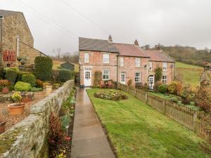 a house with a garden in front of it at Ghyll Cottage in Rosedale Abbey