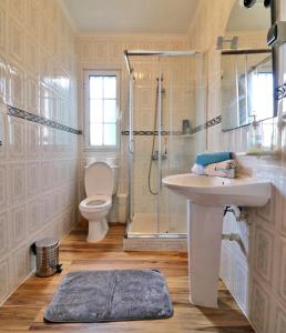 a bathroom with a sink and a shower and a toilet at Casa das Vinhas in Mosteiros +10 photos