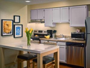 cocina con armarios blancos y encimera blanca en Sonesta ES Suites Colorado Springs en Colorado Springs