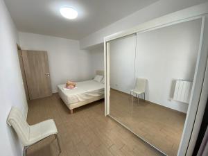 ママイアにあるSunshine Apartament De Silvaのベッドルーム1室(ベッド1台付)、スライド式ガラスドアが備わります。