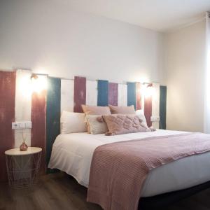 a bedroom with a large bed with a striped headboard at Hotel Rural Covarrubias in Covarrubias