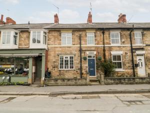 an old brick house with a blue door at Hogwarts Cottage in Pickering