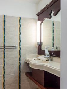 La salle de bains est pourvue d'un lavabo et d'un miroir. dans l'établissement Tropik-Appart - Studio, à Sainte-Luce