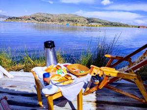 a table with bread and a basket of food next to the water at Titicaca wasy lodge in Puno