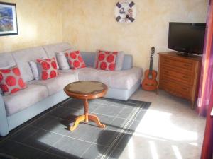 a living room with a couch and a table and a guitar at Rez-de-jardin 50 m² entre Biarritz et Capbreton in Ondres