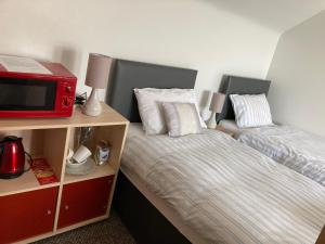 a bedroom with two twin beds and a microwave at Port House in Gairloch