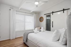 a white bedroom with a large bed and a window at Dundas Escape in Rye