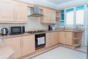 a kitchen with wooden cabinets and a stove top oven at Luxury Apartment with Ocean View in Oyster Bay in Dar es Salaam