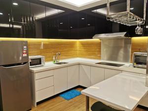 a kitchen with white cabinets and stainless steel appliances at Apple Home 1 @ Menara Simfoni/Symphony Tower C180/Cheras/Mines/Balakong/Kuala Lumpur in Seri Kembangan