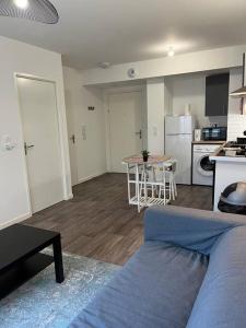 a living room with a bed and a kitchen at Appartement F2 de haut standing en hypercentre avec jardin privé à 270 m de la Gare de MANTES ! in Mantes-la-Ville