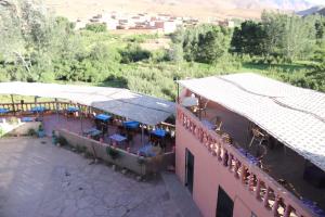 einen Blick über ein Gebäude mit Tischen und Sonnenschirmen in der Unterkunft Maison d'hôtes La vallée des nomades in Semrir
