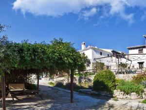 een gebouw met een bank en bomen ervoor bij Traditional cottage in Andaluc a with private terrace in Serval