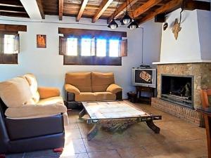 een woonkamer met een bank en een open haard bij Traditional cottage in Andaluc a with private terrace in Serval