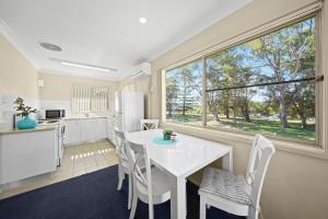 a kitchen and dining room with a white table and chairs at Sundial Holiday Units in North Haven