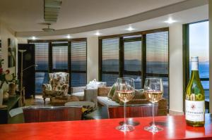 ケープタウンにあるLuxury Ocean View 1203のワイングラス2杯付きのテーブルに座ったワイン1本
