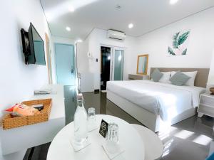 una camera d'albergo con due letti, un tavolo e una televisione di Olivia Hotel and Apartment a Nha Trang