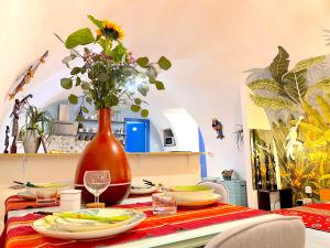 une table avec des assiettes et un vase avec des fleurs. dans l'établissement Apartment Napoli, à Naples
